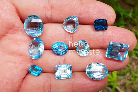 blue topaz crystal on hand carat cut