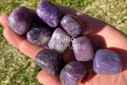 purple tumbled lepidolite crystal on hand outside photography