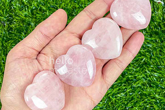 heart shaped pink rose quartz crystals on hand