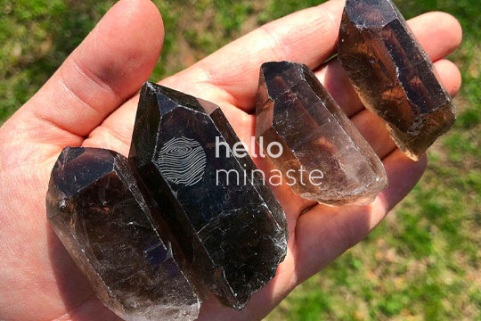 black and brown shaded smoky quartz energy tower on hand outdoor shooting