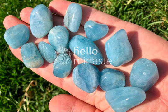 blue tumbled aquamarine stone on hand outdoor photography